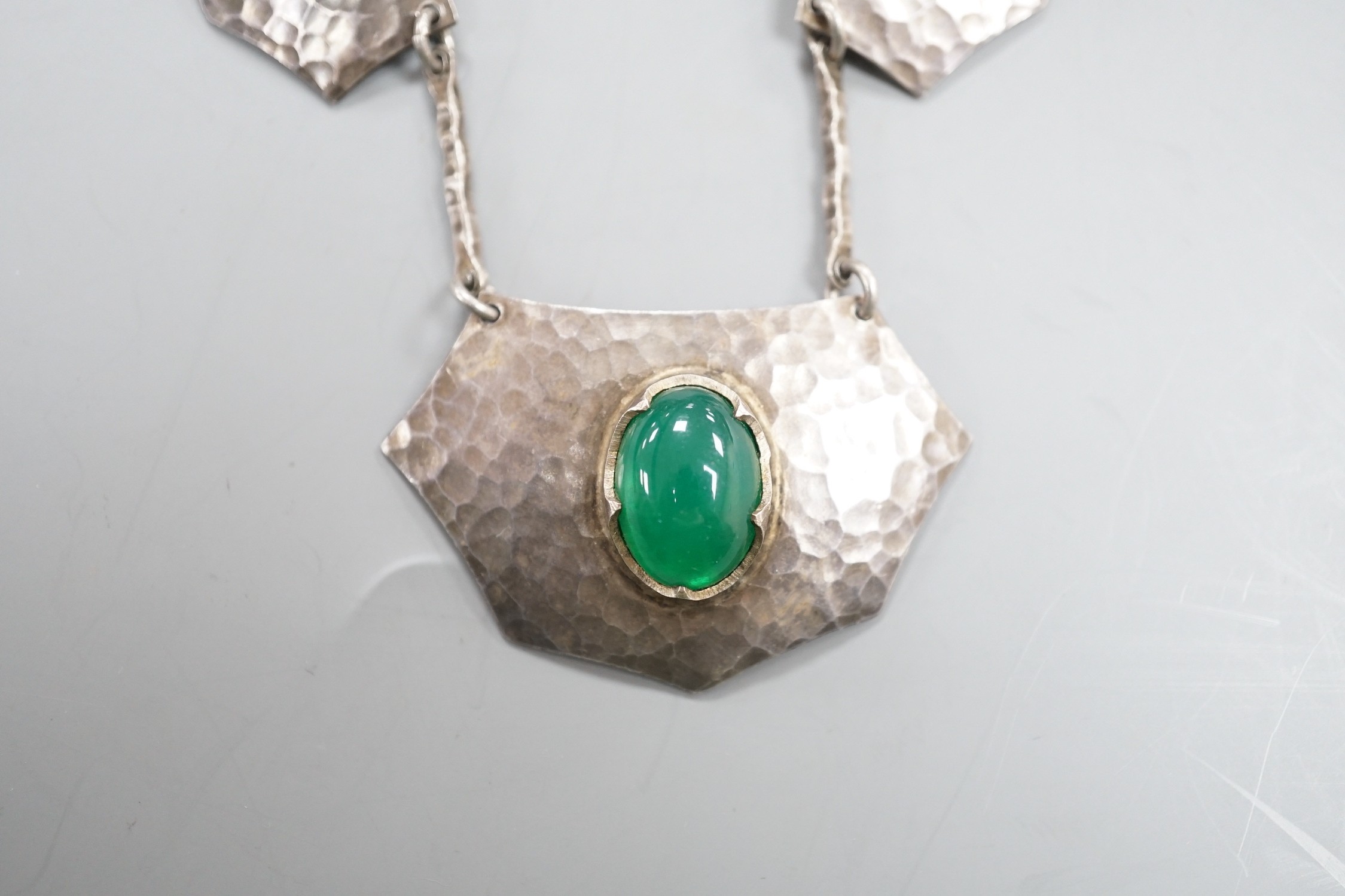 An Arts of Crafts planished white metal and five stone chrysoprase set necklace, 54cm.